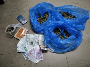 Zabezpieczone przez policjantów narkotyki w niebieskich workach oraz pieniądze.