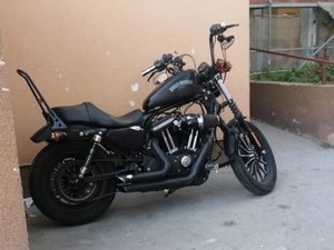 Odnaleziony Harley Davidson koloru czarnego stoi pod ścianą budynku
