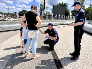 Zdjęcia przedstawiające policjantów i dzieci w trakcie akcji profilaktycznej, gdy rozdają odblaski.