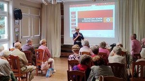 policjantka rozmawia z seniorami na temat bezpieczeństwa w ruchu drogowym