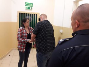 Policjantka zakłada kajdanki podejrzanemu o przemoc w rodzinie