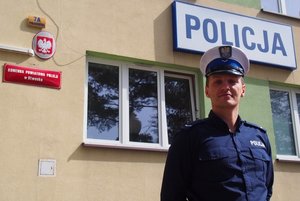 Policjant sierżant Marcin Jabłoński - Wydział Ruchu Drogowego KPP w Otwocku na tle budynku komendy