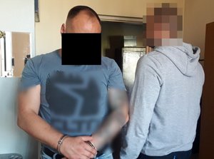 na zdjęciu widać policjanta w cywilnych ubraniach z zatrzymanym mężczyzną