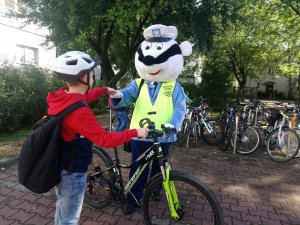 Maskotka policyjna Borsuk wspiera dzieci podczas egzaminu na kartę rowerową