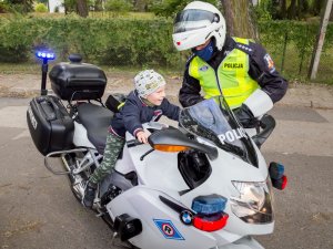 Siedzący na motocyklu policyjnym brat Tomka oraz stojący obok policjant ruchu drogowego