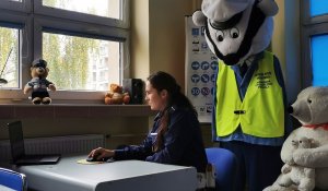 Policjantka siedząca przed komputerem prowadzi zajęcia on-line.