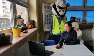 Policjantka siedząca przed komputerem prowadzi zajęcia on-line.
