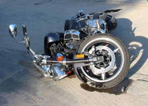 Zdjęcie przedstawia przewrócony motocykl.