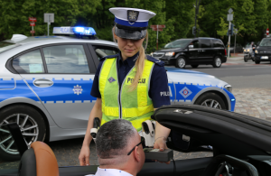 Zdjęcie przedstawia policjantkę ruchu drogowego badająca stan trzeźwości kierowcy.