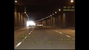 Zdjęcie przedstawia zapis wideorejestratora z policyjnego radiowozu, na którym widać poruszający się samochód w tunelu z prędkością 126 km/h na obszarze zabudowanym.