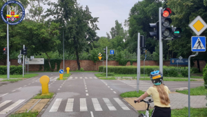 Zdjęcie przedstawia dziecko na rowerze poruszające się na miasteczku ruchu drogowego podczas egzaminu n kartę rowerową.