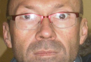 Zdjęcie przedstawia fragment twarzy mężczyzny, który ma okulary na twarzy. Mężczyzna patrzy wprost do obiektywu aparatu.
